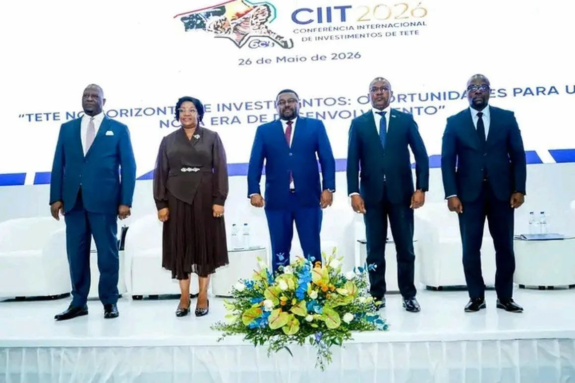 Cinco dirigentes de pé no palco do lançamento oficial da CIIT 2026, diante de um painel com o logótipo da Conferência, a data de 26 de Maio de 2026 e o lema do evento, com um arranjo de flores em primeiro plano